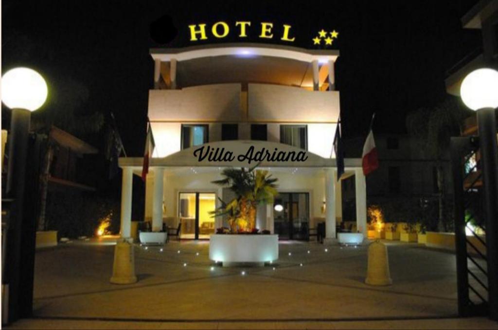 un hotel de noche con un cartel delante en Villa Adriana Hotel en Tivoli