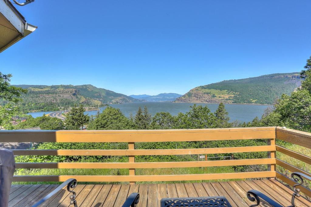 un banc en bois sur une terrasse avec vue sur le lac dans l'établissement Amber Sunset, à Mosier