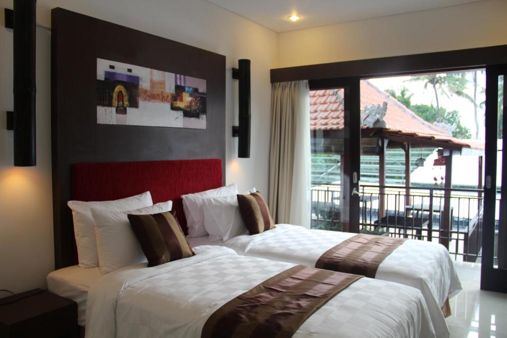 Postel nebo postele na pokoji v ubytování The Swaha Ubud Hotel