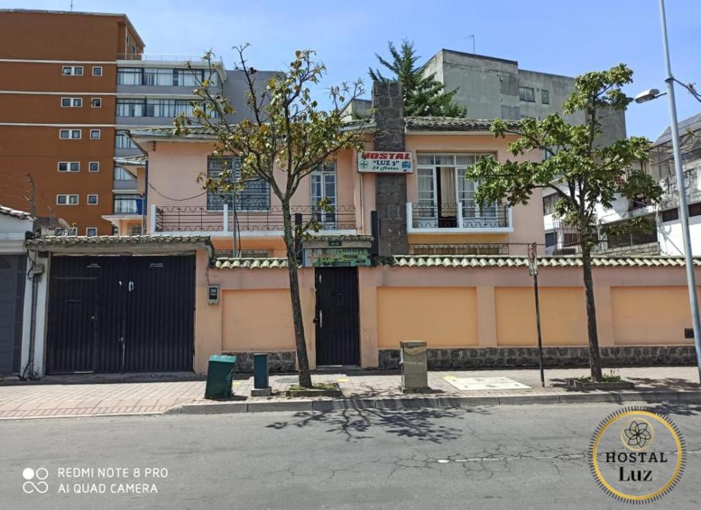 un edificio con una puerta negra en una calle de la ciudad en Hostel Luz Robles, en Quito