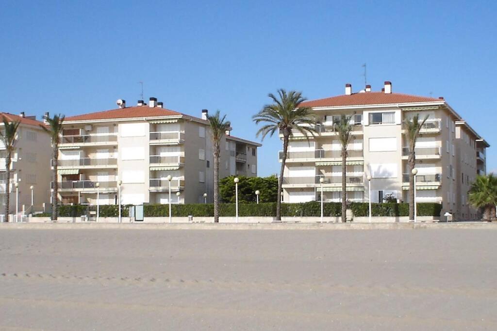 dois grandes edifícios de apartamentos na praia com palmeiras em Calafell beach experience- Calafell playa em Calafell