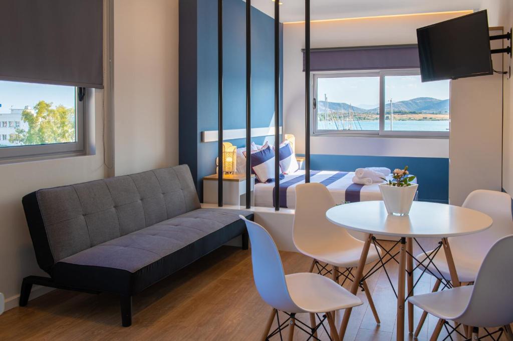 a living room with a couch and a table and a bed at Central Marine Flat in Volos