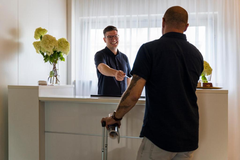 un homme se tient devant un miroir dans l'établissement Base I Hotel, à Lörrach