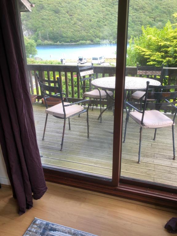 a view of a deck with tables and chairs through a window at Gwêl y Dŵr in Llanberis