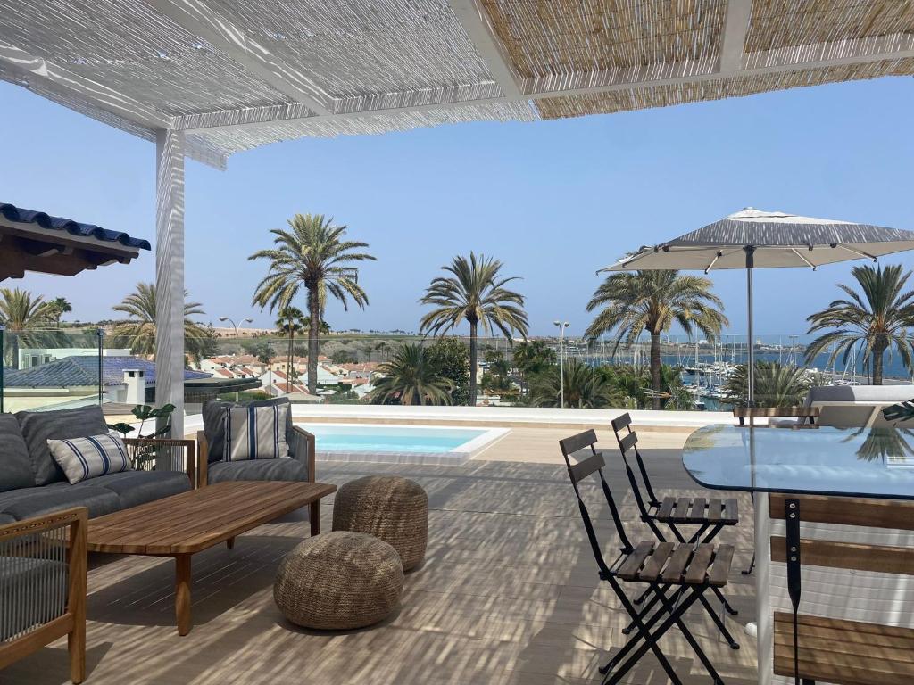 a patio with a table and chairs and a pool at Pasitoblanco Porto Mare 45 Seaview Villa prívate heated pool in Pasito Blanco
