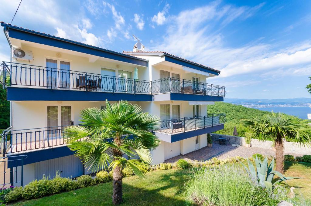 a house on the beach with palm trees at Apartments Marijana in Ičići