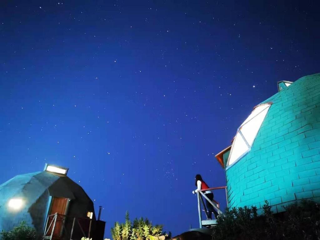 um edifício azul com uma cúpula ao lado à noite em Domos El Llano em Putaendo