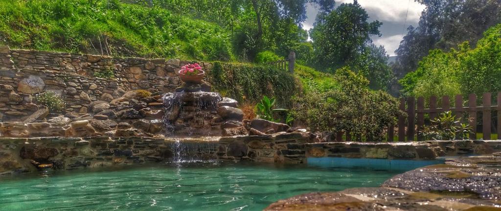 een fontein in het midden van een plas water bij A Casa das Augas in Mondoñedo