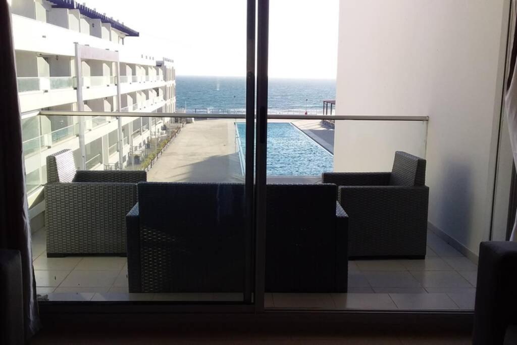 a room with a view of the ocean from a building at Appartement familial luxueux pieds dans l'eau in Aourir