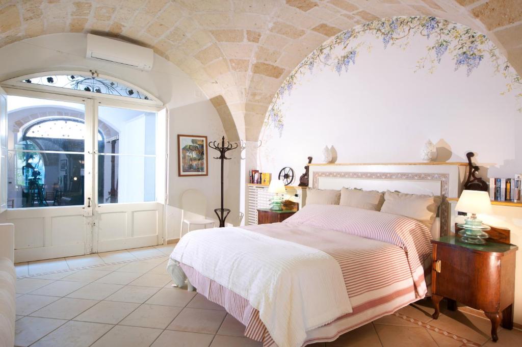 a bedroom with a bed and a large window at Casa d'Artista Suite & Garden in Lecce