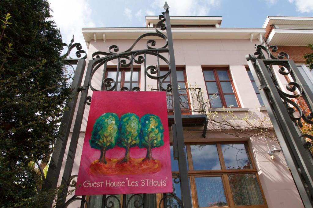 un panneau sur une porte avec trois arbres dans l'établissement Guest House Les 3 Tilleuls, à Bruxelles