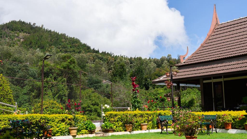 a garden with tables and chairs in front of a building at Radosri in Coonoor