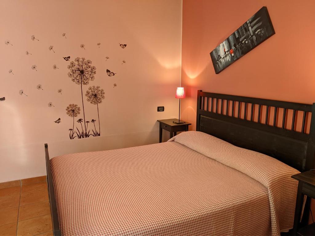 una camera da letto con un letto e fiori sul muro di La Buccetta B&B a Verona