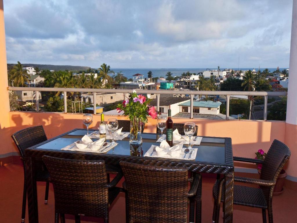 a black table with chairs and flowers on a balcony at Torre Mar Galapagos Boutique Suites in Puerto Ayora