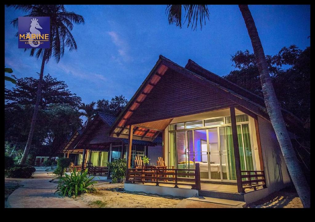 una pequeña casa con una palmera delante de ella en Marine Chaweng Beach Resort, en Chaweng