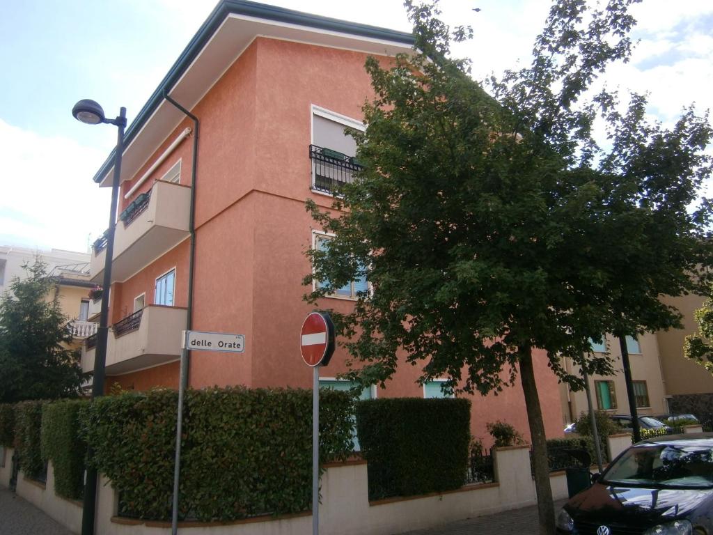 un edificio rosa con un letrero de la calle delante de él en Ca' Bosega - Agenzia Cocal, en Caorle
