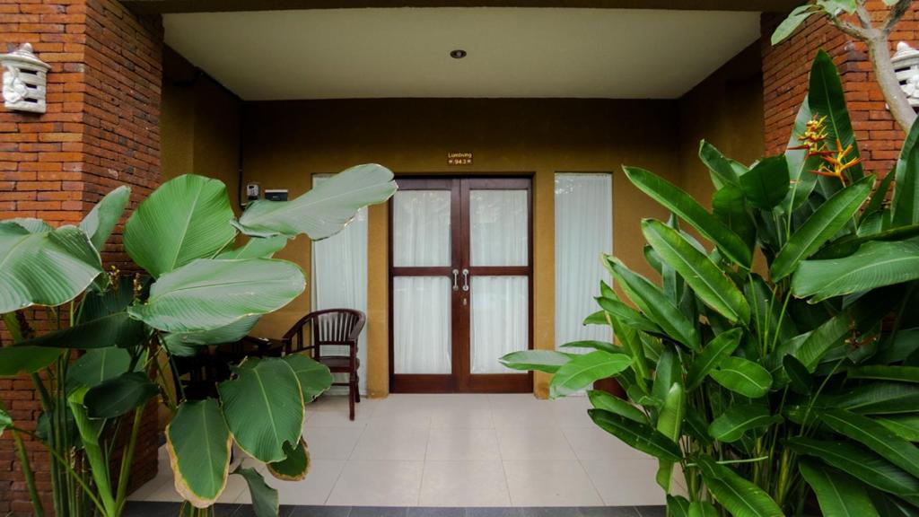 a lobby with a door and some green plants at The Janan Villa in Sanur