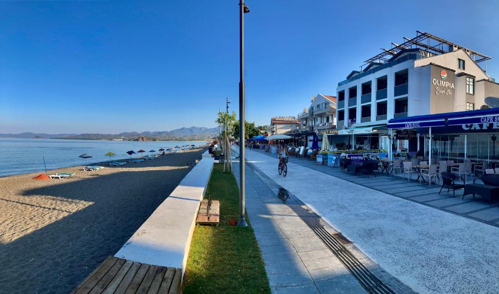 a street next to a beach with a building at Olimpia Hotel in Fethiye