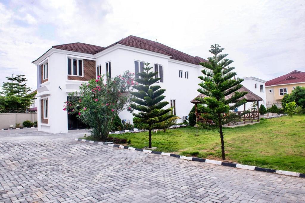 a white house with two trees in a driveway at House4 in Lekki