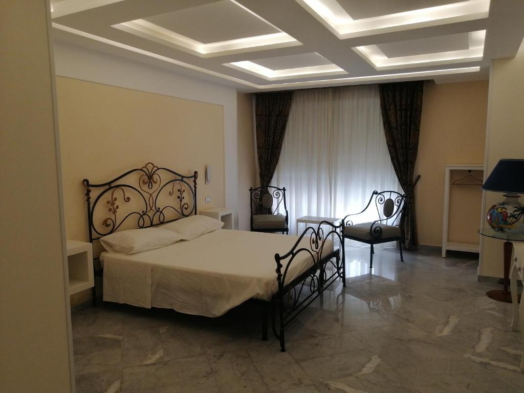 a bedroom with a large bed and two chairs at Federico 70 Zaffiro Luxury in Palermo