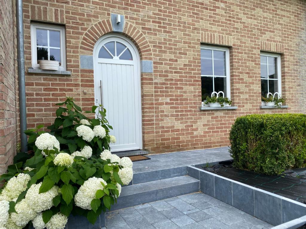 a white door on the side of a brick building at BB La Marinière in Theux