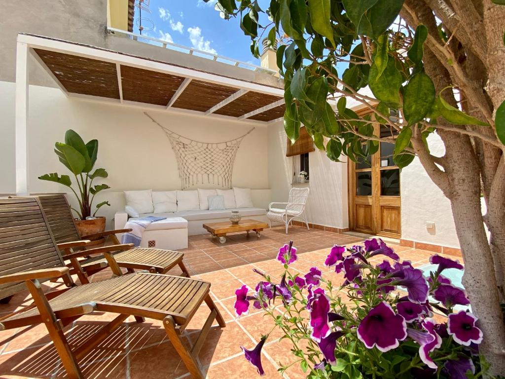 un patio con sofá, mesas y flores en Ca'n Perlita en Palma de Mallorca