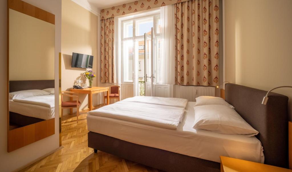 a bedroom with two beds and a window at Hotel Post Wien in Vienna