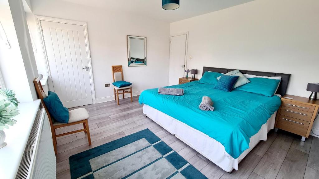 a bedroom with a large bed with blue pillows at Airport Reach in Southend-on-Sea