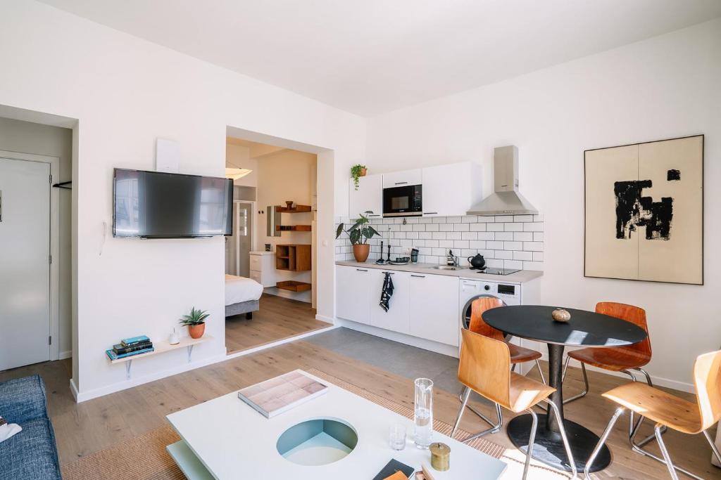 a living room with a table and a kitchen at Smartflats - Louise Brussels in Brussels
