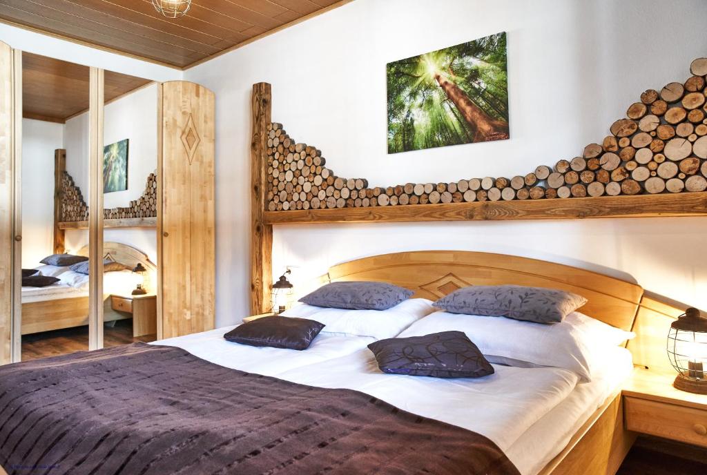 - une chambre avec un grand lit et une tête de lit en bois dans l'établissement Ferienwohnung Bergerlebnis Ötscher, à Lackenhof