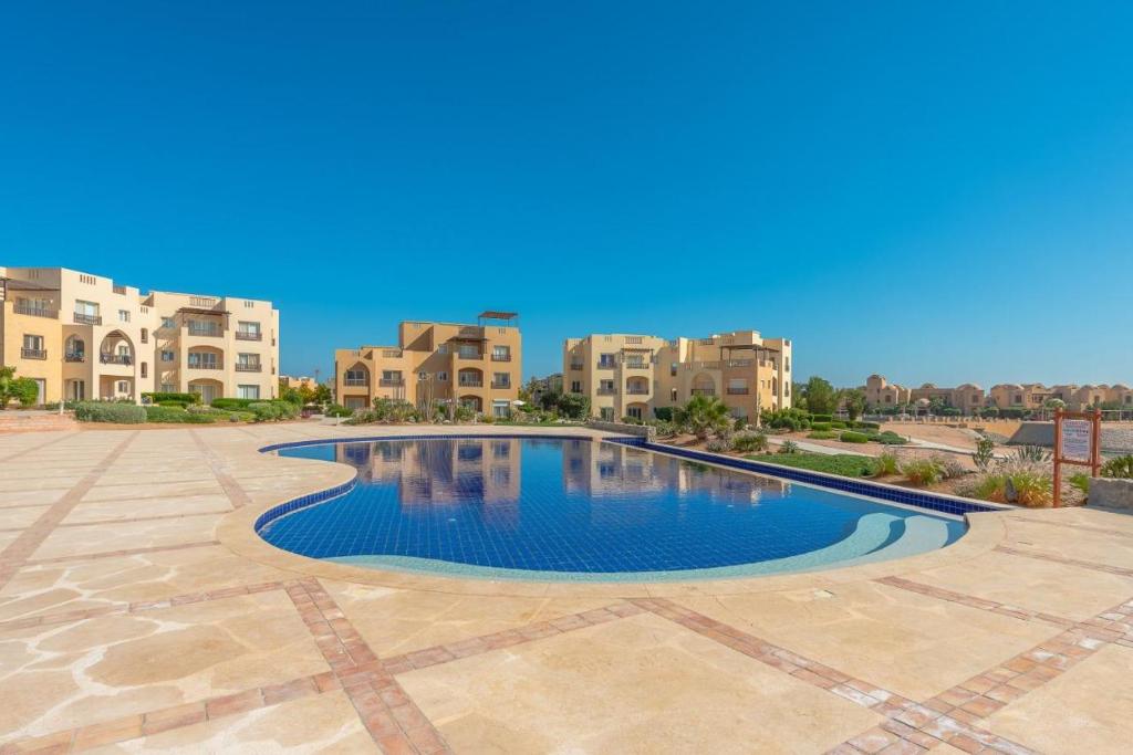 a pool in the middle of a courtyard with apartment buildings at Waterside Apartments, El Gouna 1Bd plus Private Roof Terrace in Hurghada
