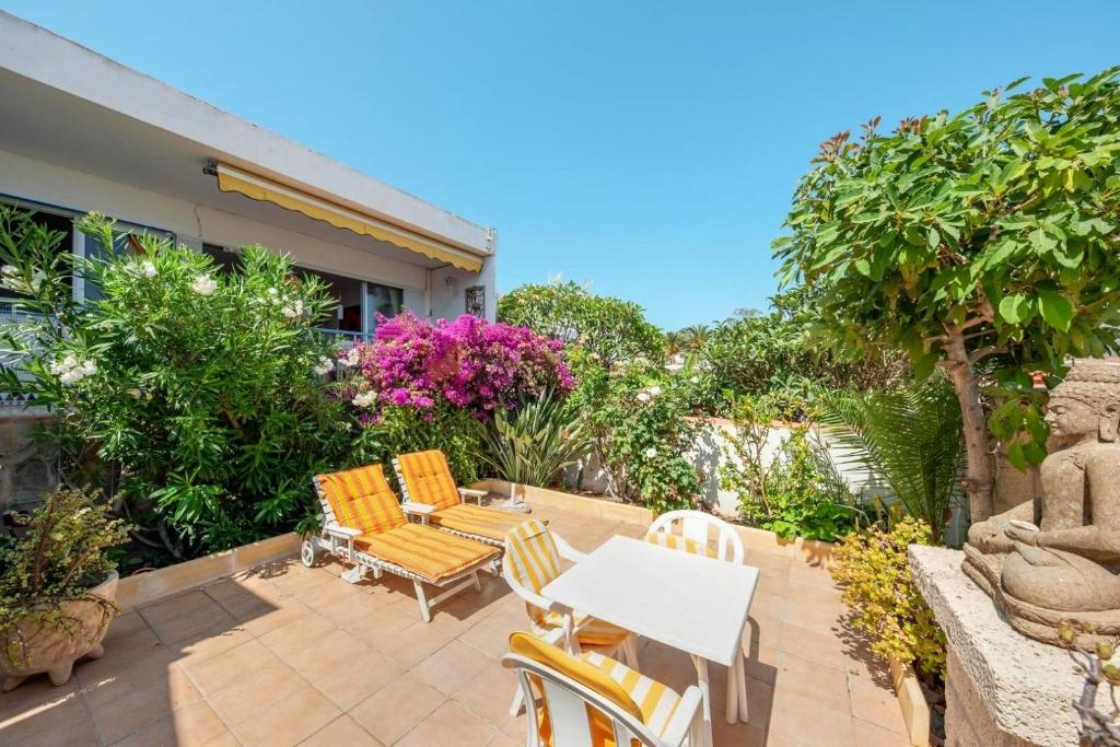 a patio with a table and chairs and flowers at Captivating 1-Bed House in Arona in Arona