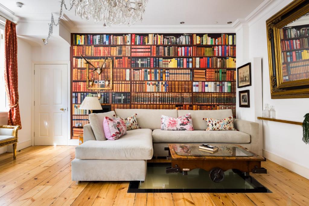 a living room with a large wall of books at Sherlocks in London
