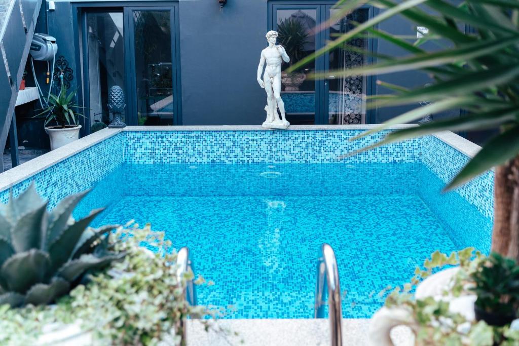 uma piscina com uma estátua ao lado de uma casa em alojamento maritimo II em Espinho