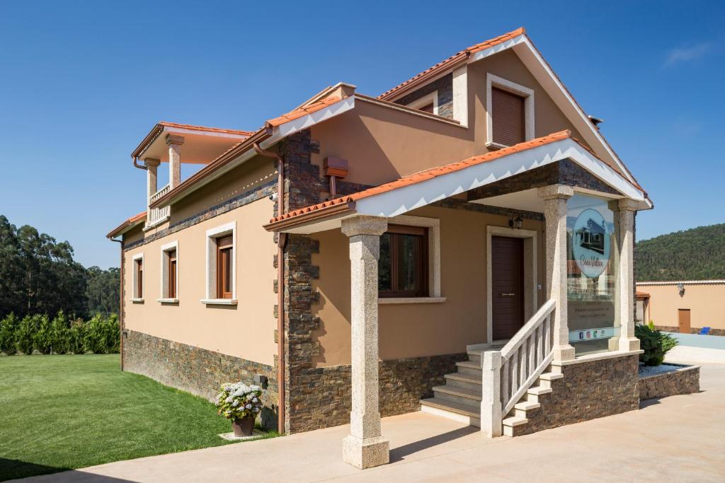 ein Haus mit einer Veranda und einer Liegewiese in der Unterkunft GALIHOST - Casa Valboa in Meis