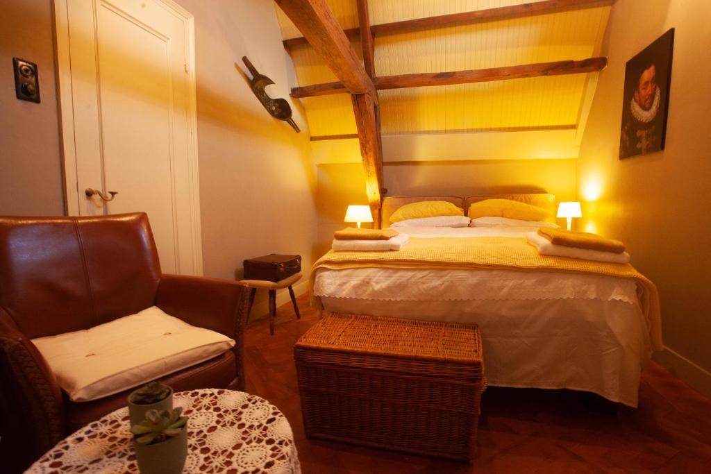 sypialnia z dużym łóżkiem i krzesłem w obiekcie BenB FirstClassEnglish w mieście Dordrecht