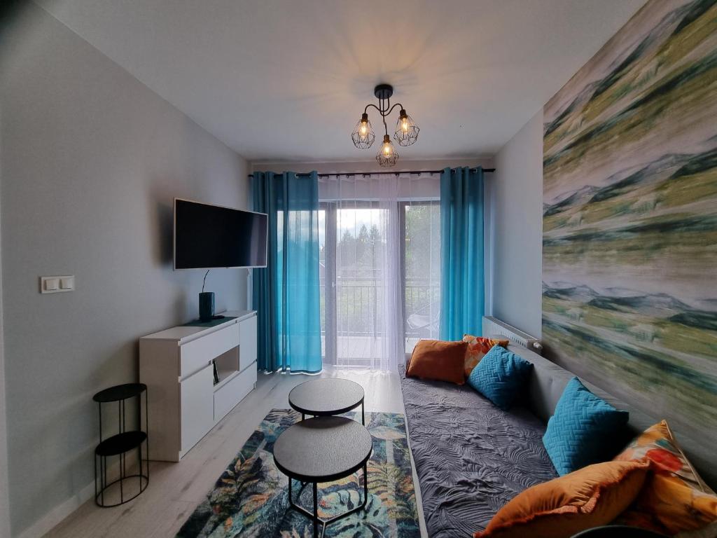 un soggiorno con divano e TV di Apartament Szmaragdowy w Karpatia - 5D Apartamenty a Karpacz