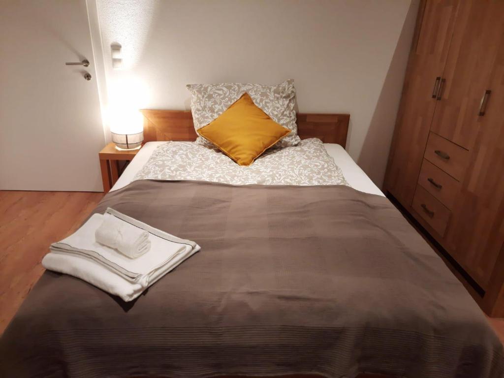 - une chambre avec un grand lit et un oreiller jaune dans l'établissement Appartment Römerstrasse, à Brixlegg