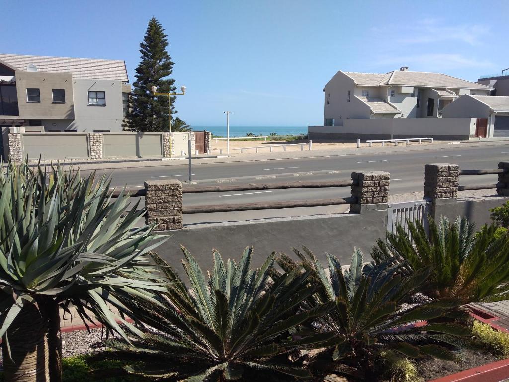 a street with a row of benches and palm trees at 20 on Beach Road in Swakopmund