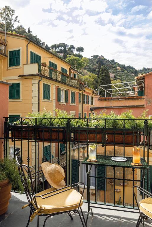 a balcony with chairs and a table and some buildings at Splendido Mare, A Belmond Hotel, Portofino in Portofino