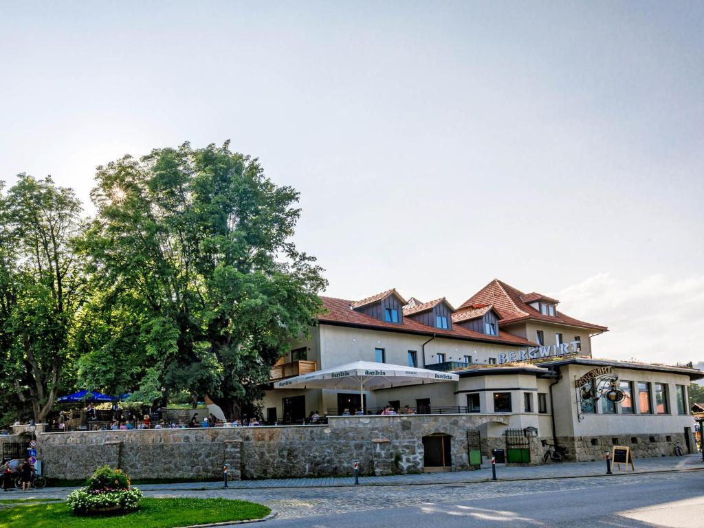 a building with people sitting outside of it at Bergwirt Hotel & Gasthof in Kiefersfelden