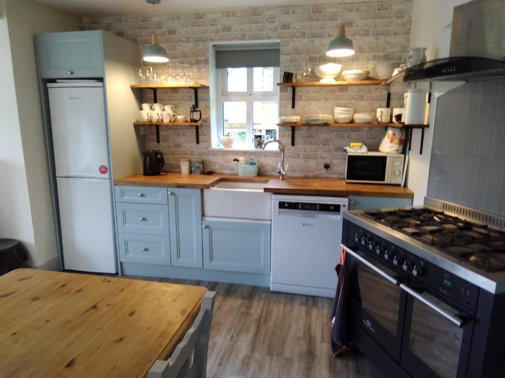 a kitchen with white appliances and a wooden table at 43 Reidhlean Clifden Glen in Galway