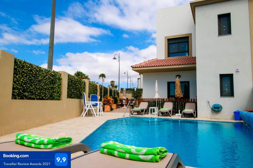 a swimming pool in front of a house at Villa Golf y Mar in San Miguel de Abona