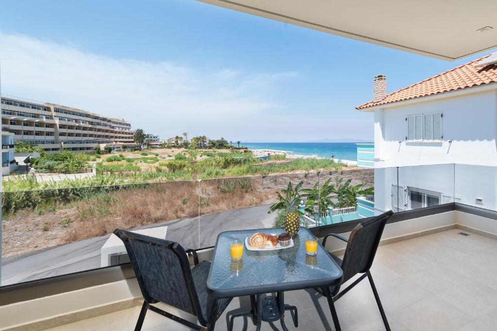 a table and chairs on a balcony with a view of the ocean at Ixia Breeze 3 in Ixia