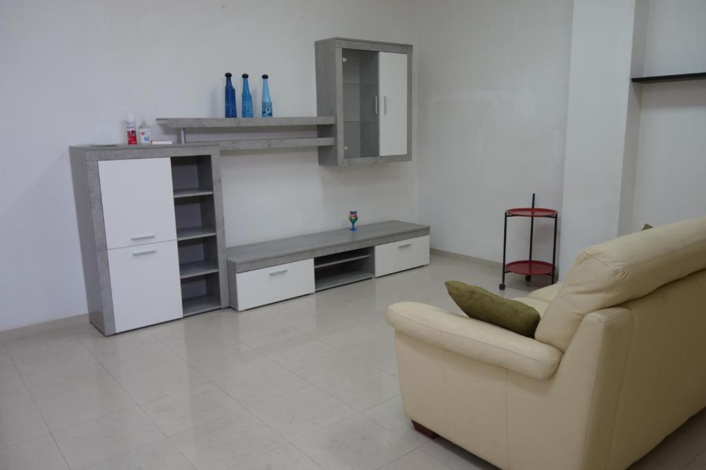ein Wohnzimmer mit einem Sofa und einem Tisch in der Unterkunft Casa Don Mario in Ispica