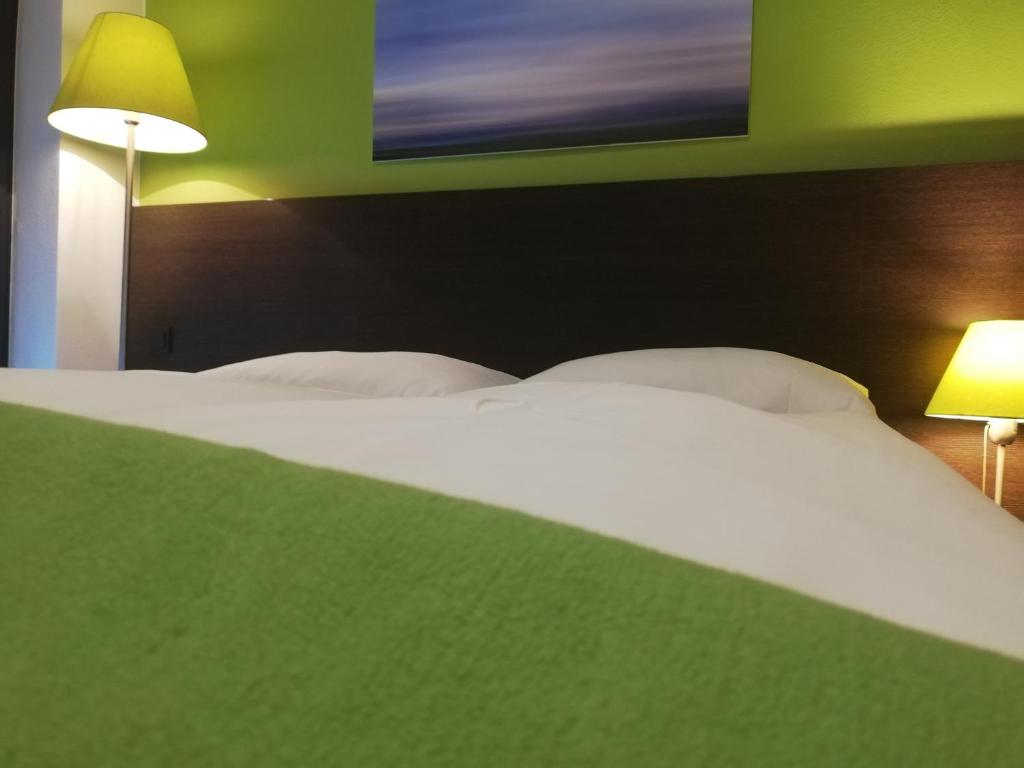 Postel nebo postele na pokoji v ubytování KH Hotel mit Restaurant