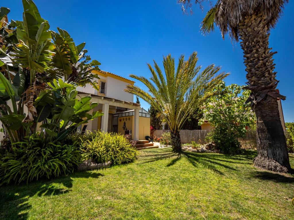 una casa con palmeras en el patio en Chalet Sol y Mar by Ĥ, en Isla Canela