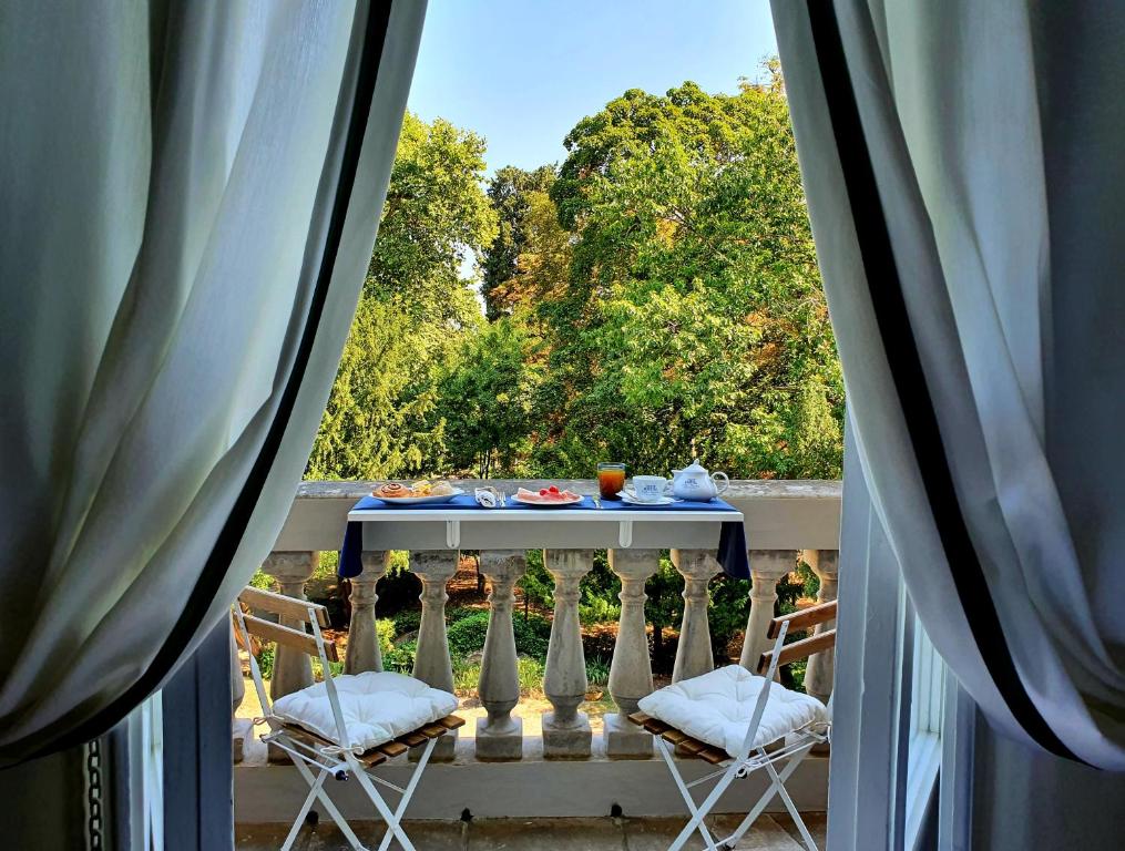 una mesa y sillas en un balcón con vistas en Villa Nardi - Residenza D'Epoca, en Florencia