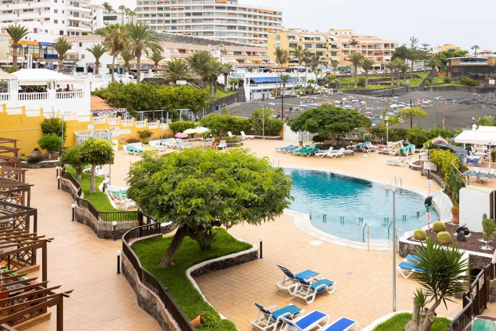 Blick auf einen Pool mit einem Resort in der Unterkunft 120 PLAYA DE LA ARENA Holiday Home by Sunkeyrents in Puerto de Santiago