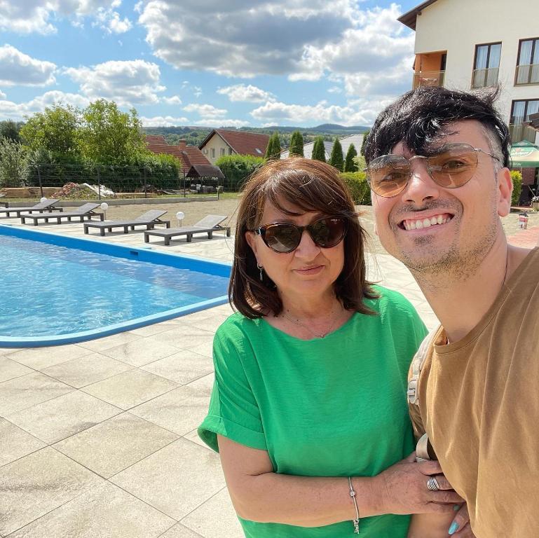 a man and a woman standing next to a pool at Hanul Conitei in Sovata